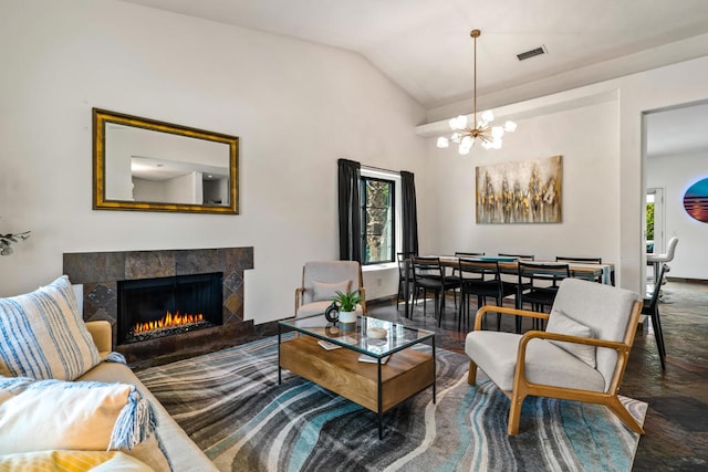 living room featuring vaulted ceiling, a fireplace, and an inviting chandelier