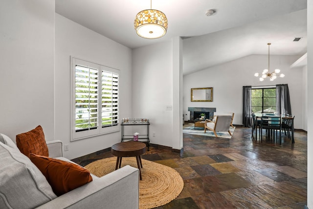 living room featuring a chandelier, vaulted ceiling, and plenty of natural light