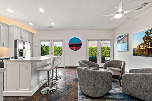 living room featuring french doors and ceiling fan