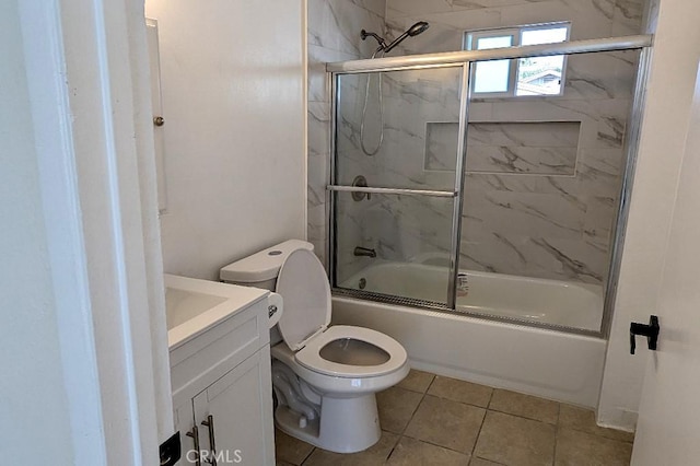 full bathroom featuring shower / bath combination with glass door, vanity, tile patterned flooring, and toilet