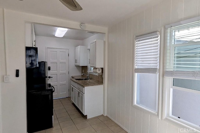 kitchen featuring stone counters, sink, ceiling fan, light tile patterned flooring, and white cabinetry