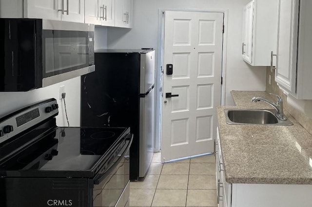 kitchen with white cabinets, range with electric stovetop, light tile patterned flooring, and sink