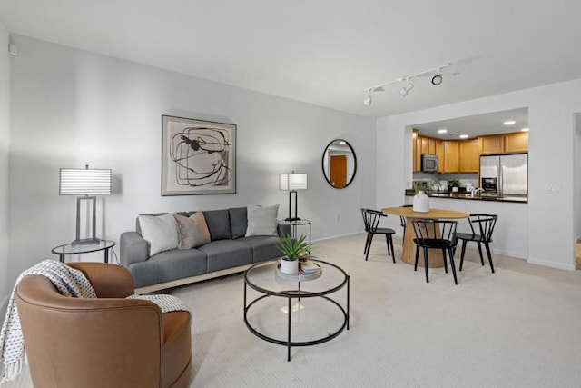 living room with light colored carpet and track lighting