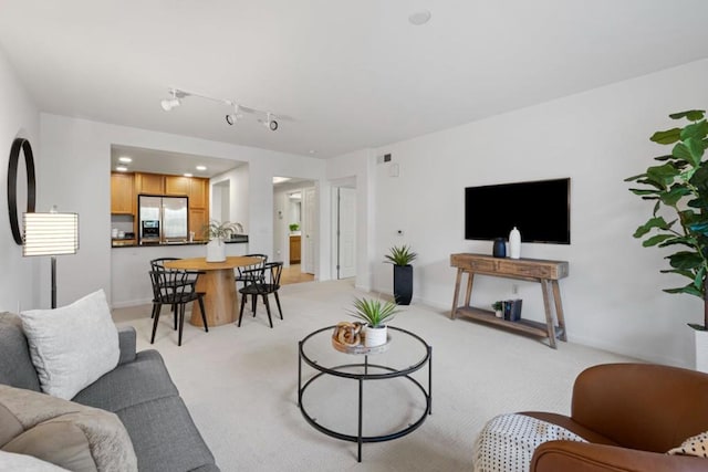 living room featuring rail lighting and light carpet