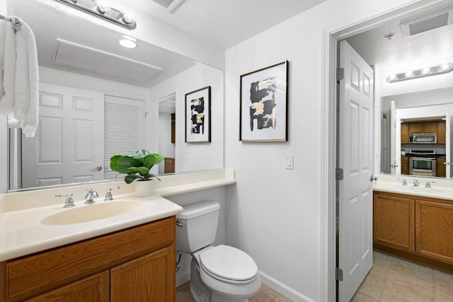 bathroom featuring toilet, vanity, and tile patterned floors