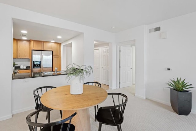 dining area featuring light carpet