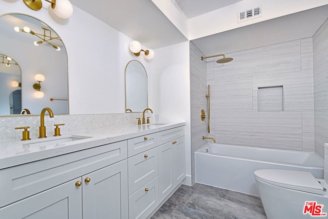 full bathroom with vanity, tiled shower / bath combo, and toilet