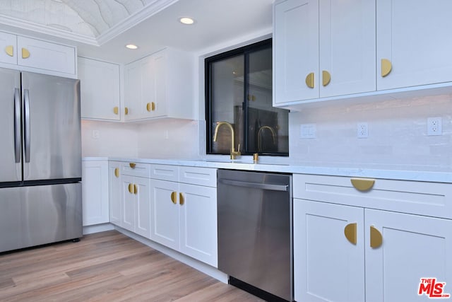 kitchen with white cabinetry, ornamental molding, light wood-type flooring, and appliances with stainless steel finishes