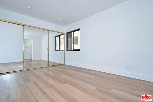 unfurnished bedroom featuring a closet and light hardwood / wood-style flooring