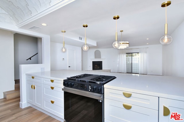 kitchen featuring white cabinetry, black gas stove, pendant lighting, and light hardwood / wood-style flooring