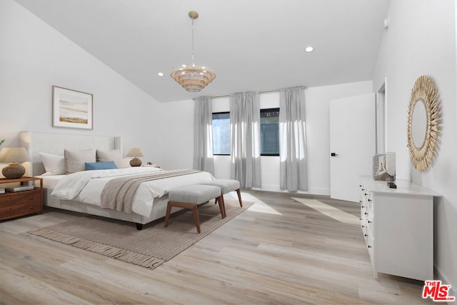 bedroom with light hardwood / wood-style flooring, a chandelier, and lofted ceiling