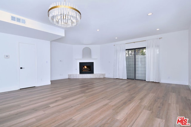 unfurnished living room featuring light hardwood / wood-style floors and a notable chandelier