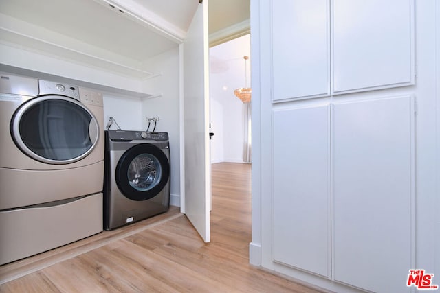 clothes washing area featuring washer and dryer and light wood-type flooring