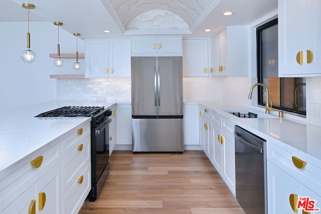 kitchen featuring appliances with stainless steel finishes, light wood-type flooring, white cabinetry, and backsplash