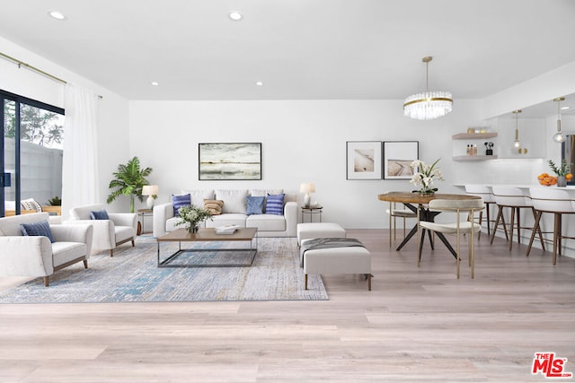 living room featuring a notable chandelier and light wood-type flooring