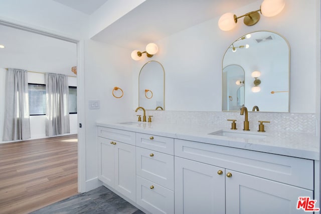 bathroom featuring vanity, wood-type flooring, and backsplash