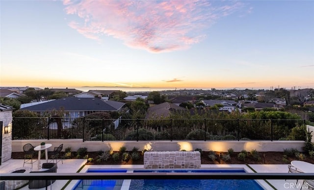 pool at dusk with a patio area