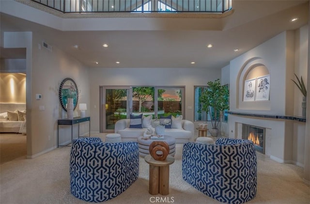 living room featuring light carpet and a towering ceiling