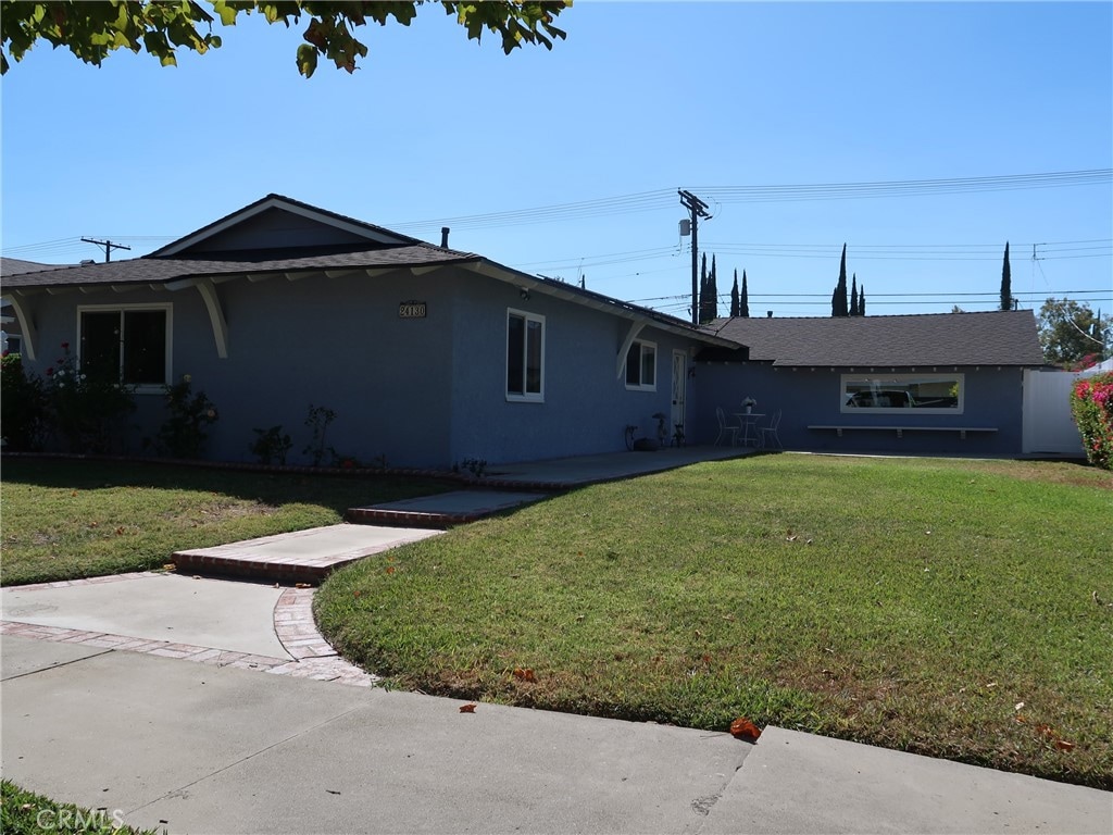 view of front of house with a front yard and a patio