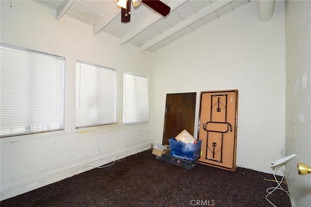 spare room with a healthy amount of sunlight, ceiling fan, and lofted ceiling with beams