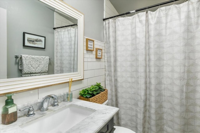 bathroom with vanity, tile walls, and toilet