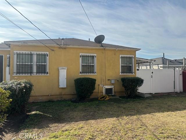 315 E 118th St, Los Angeles, CA 90061 - view of property exterior featuring stucco siding and a gate