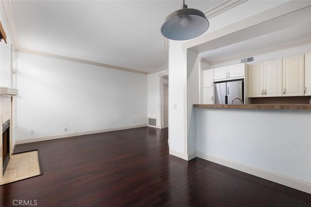 unfurnished living room with dark hardwood / wood-style flooring and ornamental molding