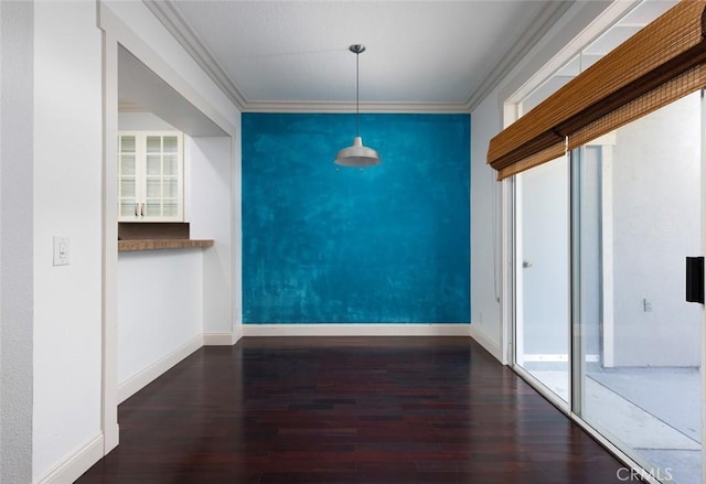 unfurnished dining area with dark hardwood / wood-style flooring and ornamental molding