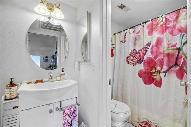 bathroom featuring toilet, walk in shower, and vanity