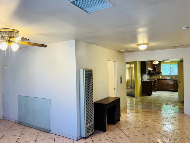 interior space featuring light tile patterned flooring, sink, backsplash, dark brown cabinets, and ceiling fan