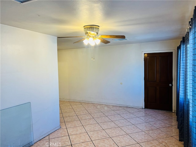 tiled empty room featuring ceiling fan