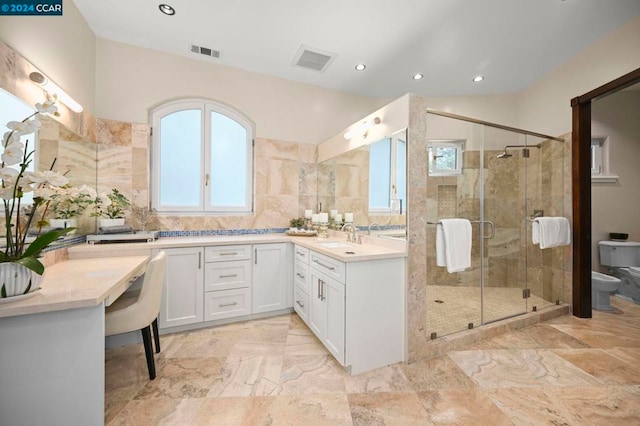 bathroom featuring vanity, toilet, a shower with door, and a bidet