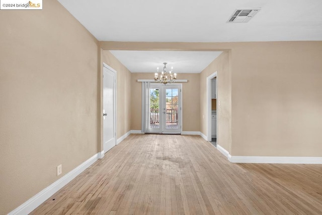 interior space featuring a notable chandelier, light wood-type flooring, and french doors