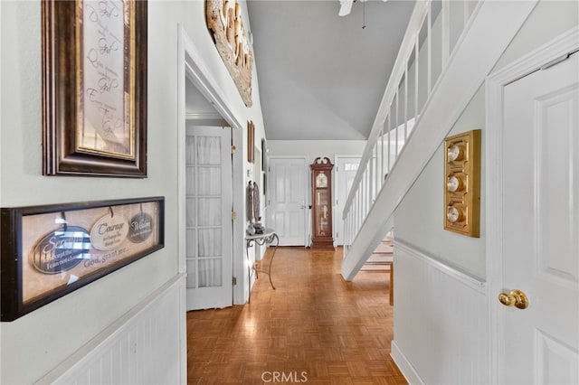 hallway with parquet floors and vaulted ceiling