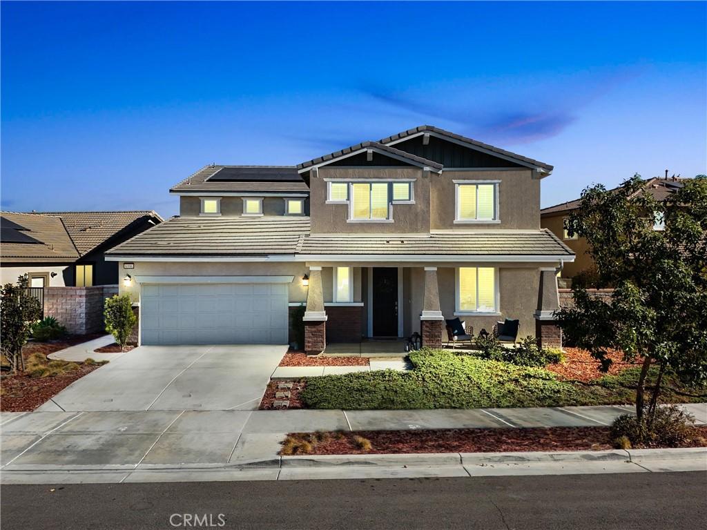 craftsman-style house featuring covered porch, solar panels, and a garage