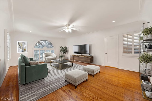 living room featuring wood-type flooring and ceiling fan