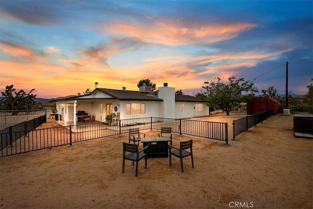 back house at dusk with a patio and an outdoor fire pit