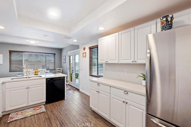 kitchen featuring dishwasher, white cabinets, stainless steel fridge, and sink