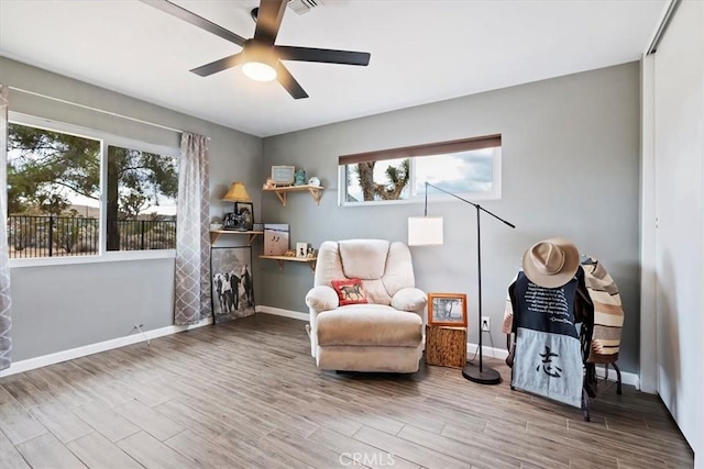 living area featuring hardwood / wood-style flooring and ceiling fan