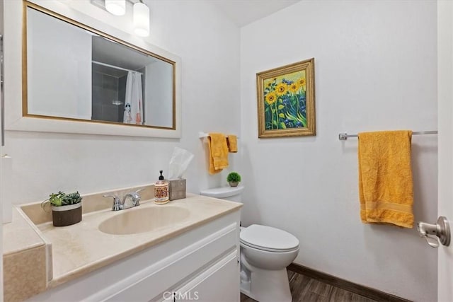 bathroom with hardwood / wood-style floors, toilet, vanity, and a shower with curtain