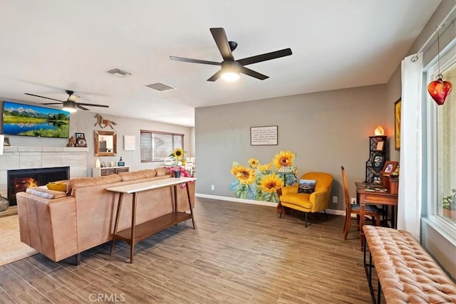 living room featuring ceiling fan, radiator, and a fireplace