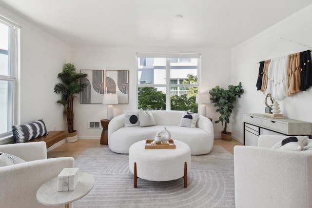 living room with plenty of natural light and light hardwood / wood-style flooring