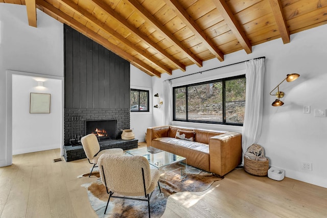 living room with a fireplace, wood ceiling, beamed ceiling, high vaulted ceiling, and light hardwood / wood-style flooring