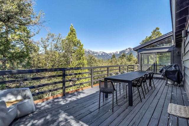 wooden deck with a mountain view and area for grilling