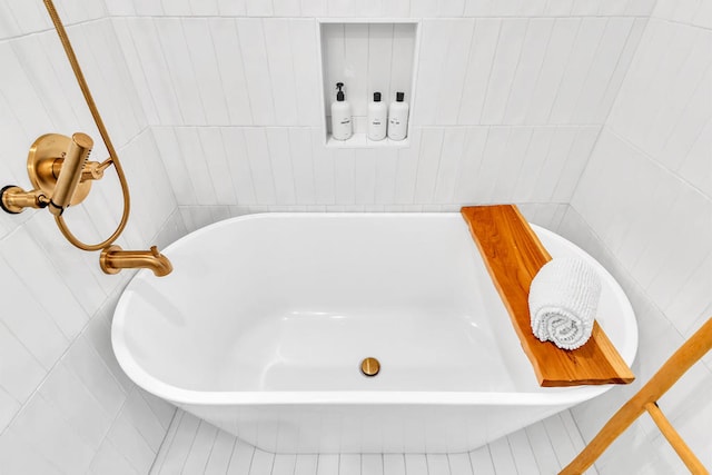 bathroom featuring a bath, tile walls, and tile patterned flooring