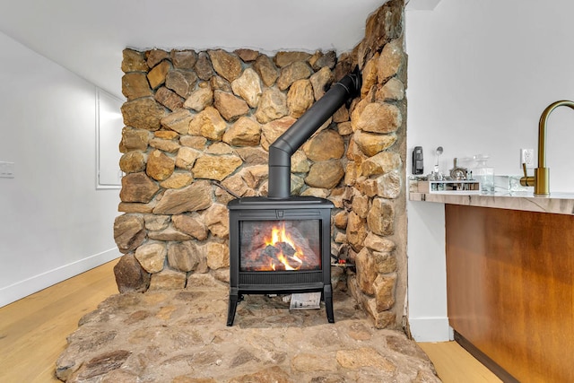 interior details with wood-type flooring and a wood stove