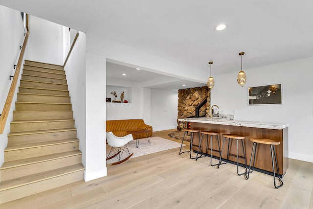 interior space featuring pendant lighting, sink, and light wood-type flooring