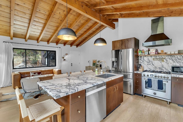 kitchen with extractor fan, stainless steel appliances, lofted ceiling with beams, decorative light fixtures, and light hardwood / wood-style floors