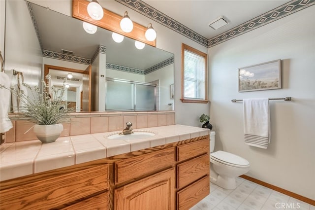 bathroom featuring vanity, toilet, and a shower with door