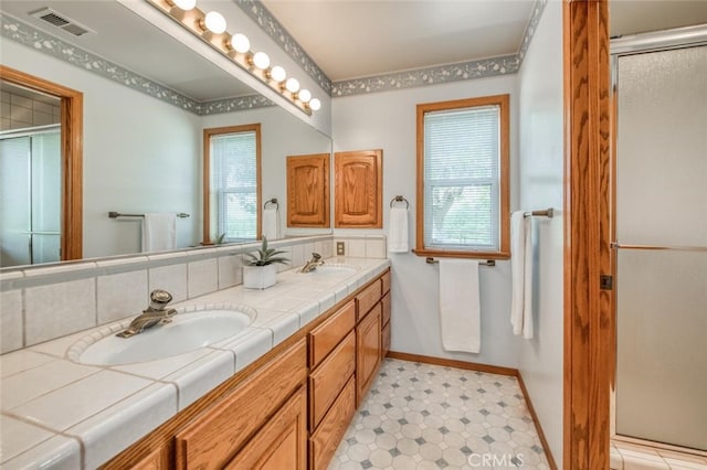 bathroom featuring vanity, walk in shower, and plenty of natural light